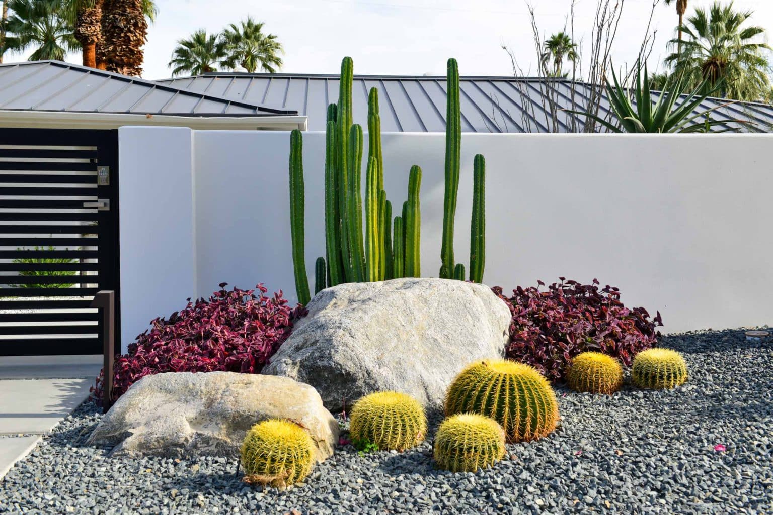Complete landscape transformation in Palm Springs. Installation includes acid washed hardscape layout, outdoor living area with pizza oven, BBQ, Fireplace, Outdoor shower with breeze block, low voltage lighting, boulders, irrigation and desert plants. Design also includes new driveway automatic gate and new pedestrian entry gate and new garden walls in front yard.