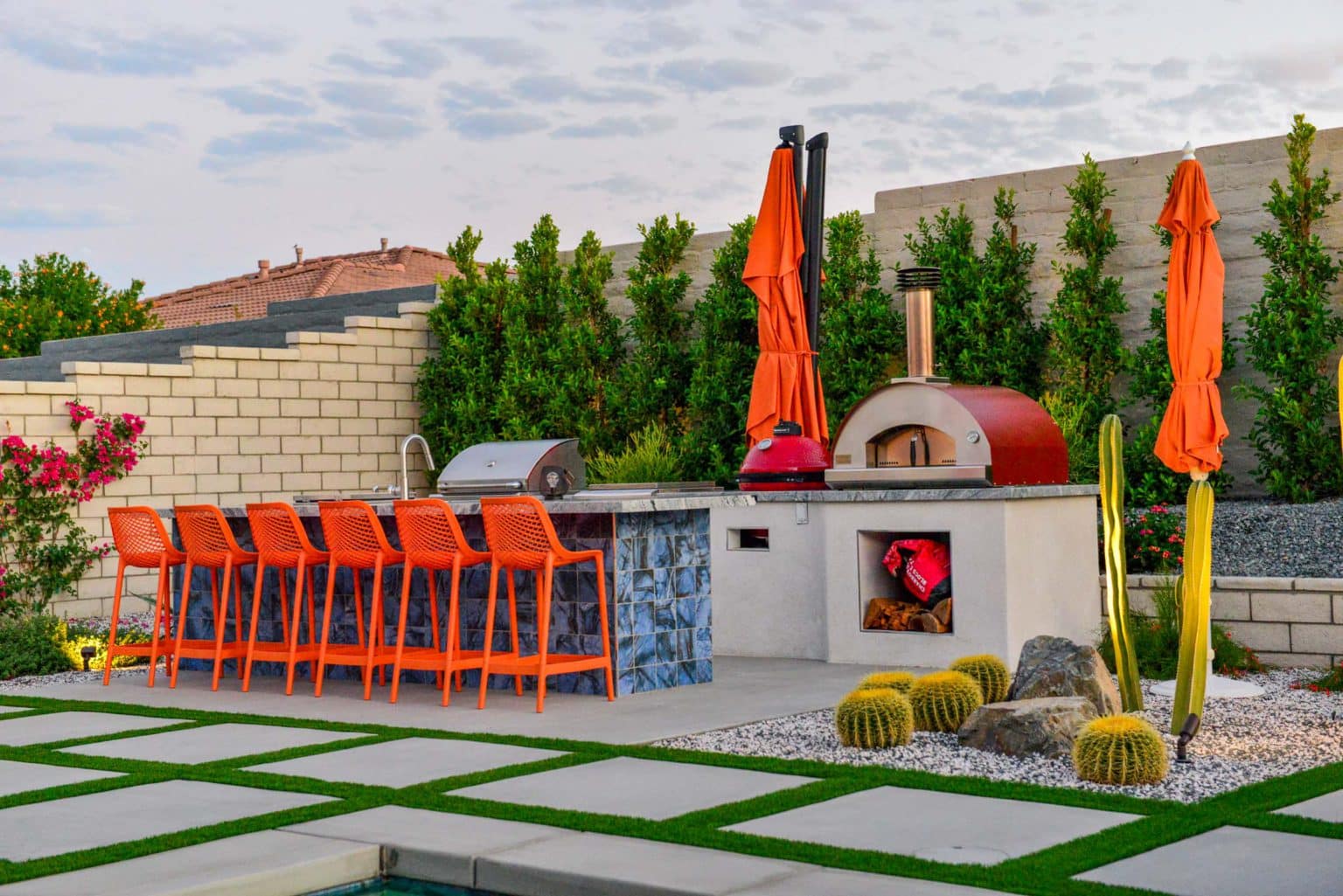 Backyard landscape transformation in Rancho Mirage, including hardscape, outdoor kitchen with pizza oven, low voltage lighting, Boulders, decomposed granite, artificial turf, irrigation and desert plants.